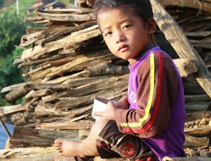Nepal earthquake response — child in purple jacket with book